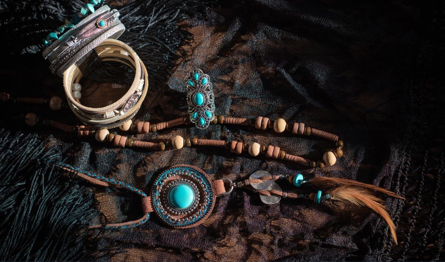 Bracelets, a ring, and a beaded necklace laid out on dark fabric before being placed in a jewelry safe